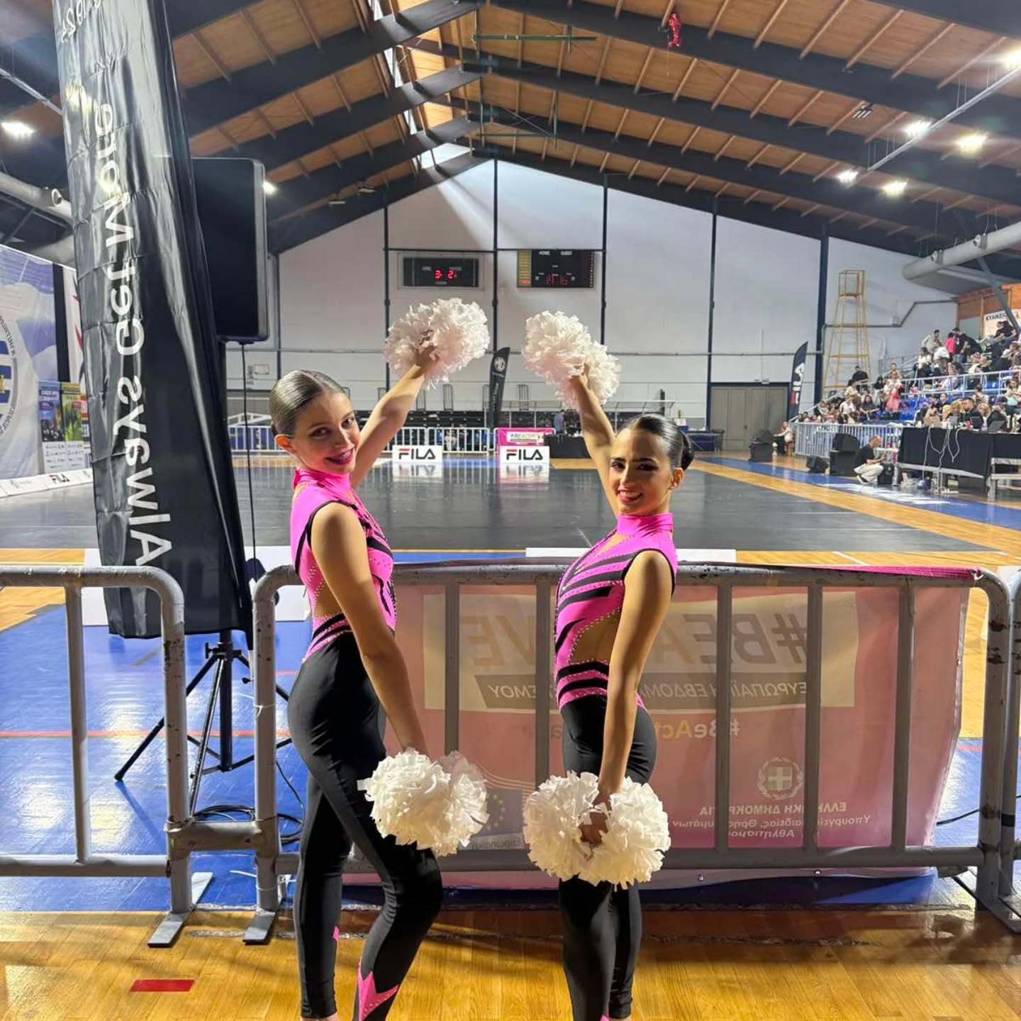 Αθλήτριες cheerleading με πομ πομ σε αγώνα